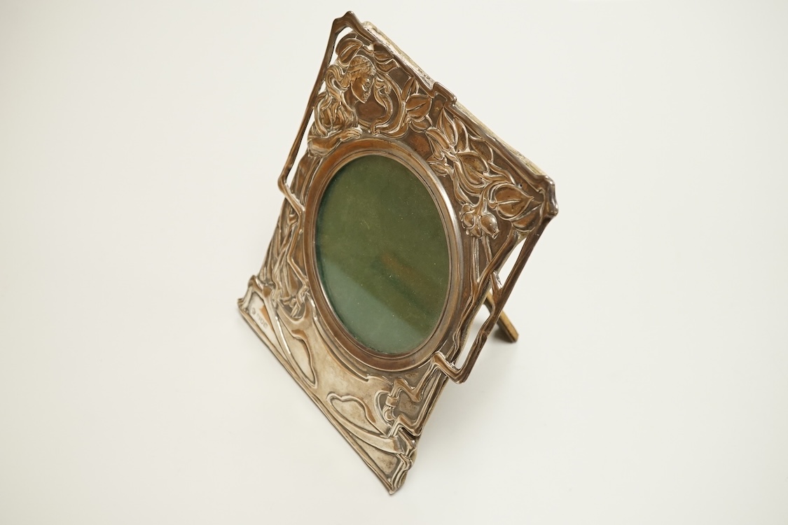 An Edwardian Art Nouveau silver mounted shaped rectangular photograph frame, by William Hutton & Sons, London 1901, decorated with a maiden amongst foliage, 19.5cm.